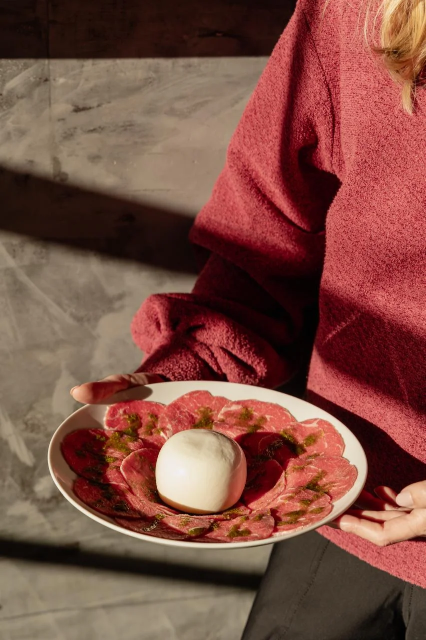 Prato de carpaccio com mozzarella fresca ao centro em apresentação gourmet