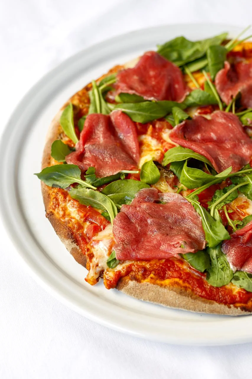 Pizza com presunto cru, rúcula fresca e queijo derretido