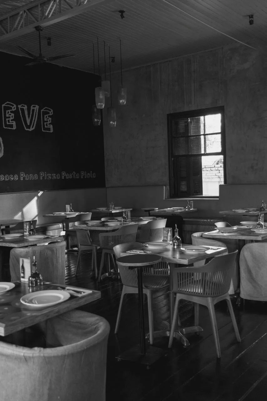 Salão da Piola com mesas preparadas em fotografia preto e branco